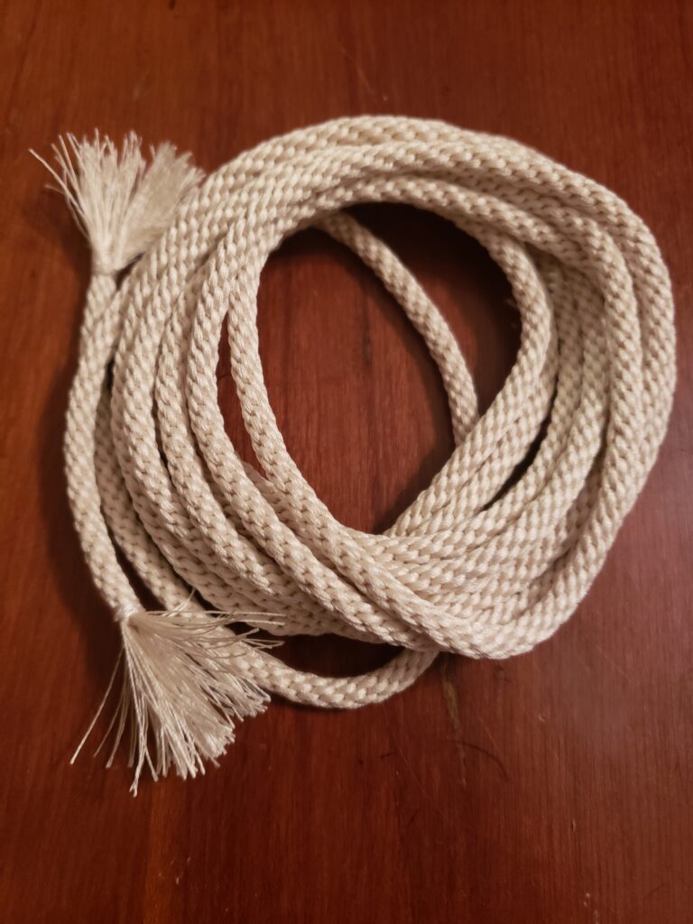 A coil of braided cord with tasseled ends.